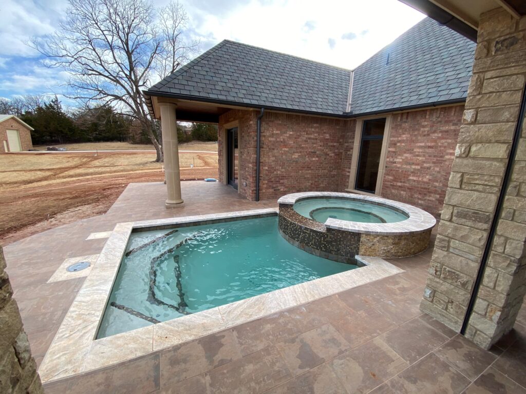 A multilevel in-ground pool with a square bottom and circular top level, showcasing a breathtaking coating finish.