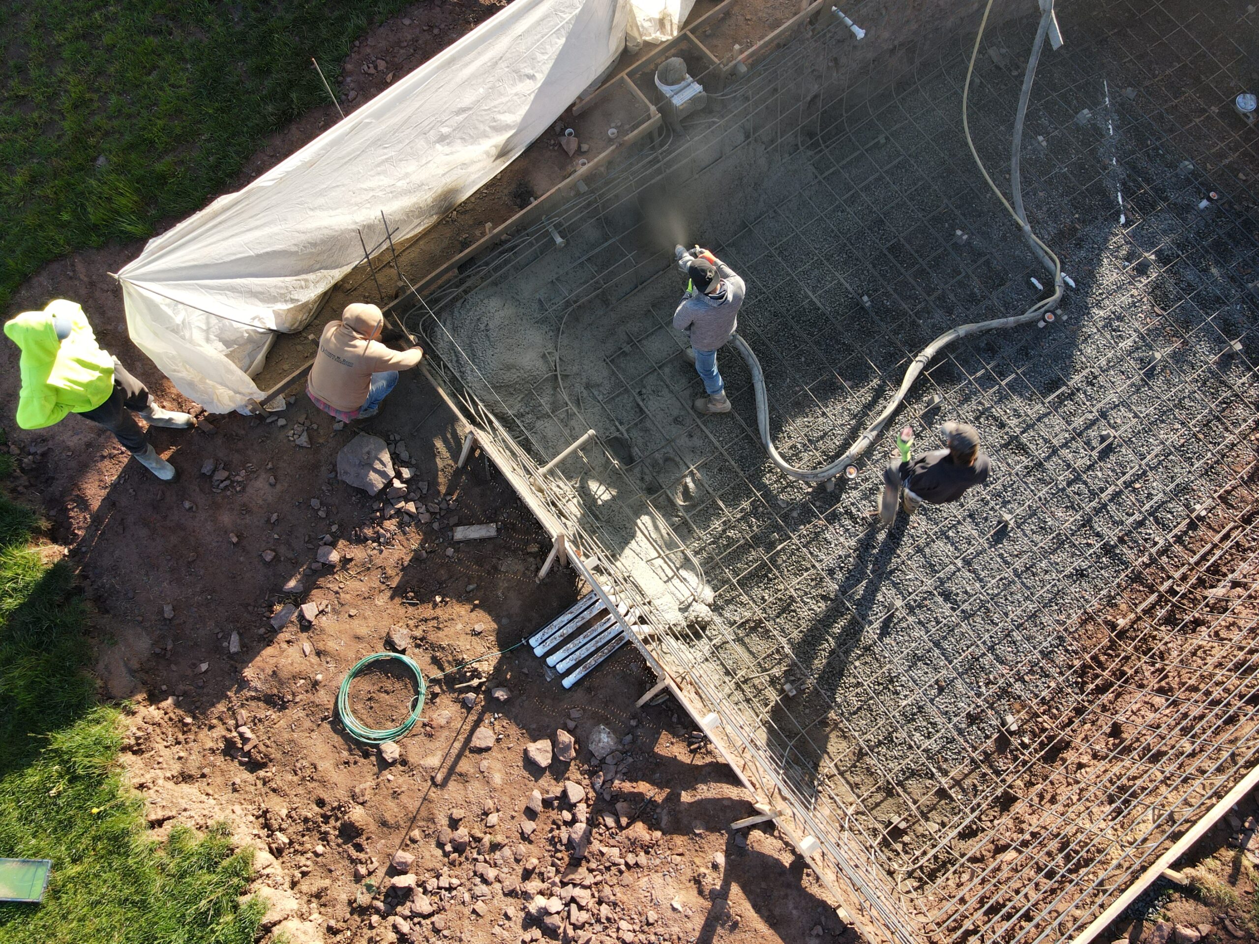 The start of an in-ground pool construction project with workers on site.