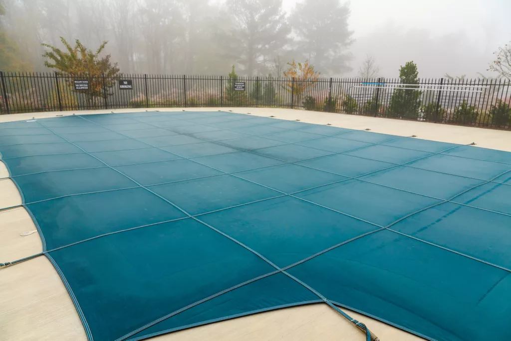 A pool cover on top of an inground swimming pool.