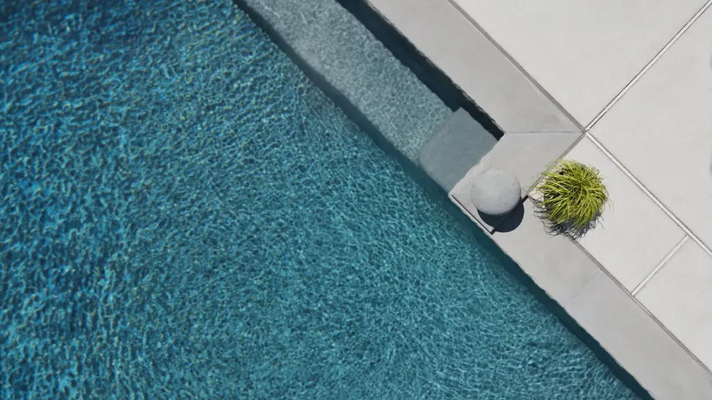 a birds-eye view of an inground swimming pool with an aquabright coating from ecofinish